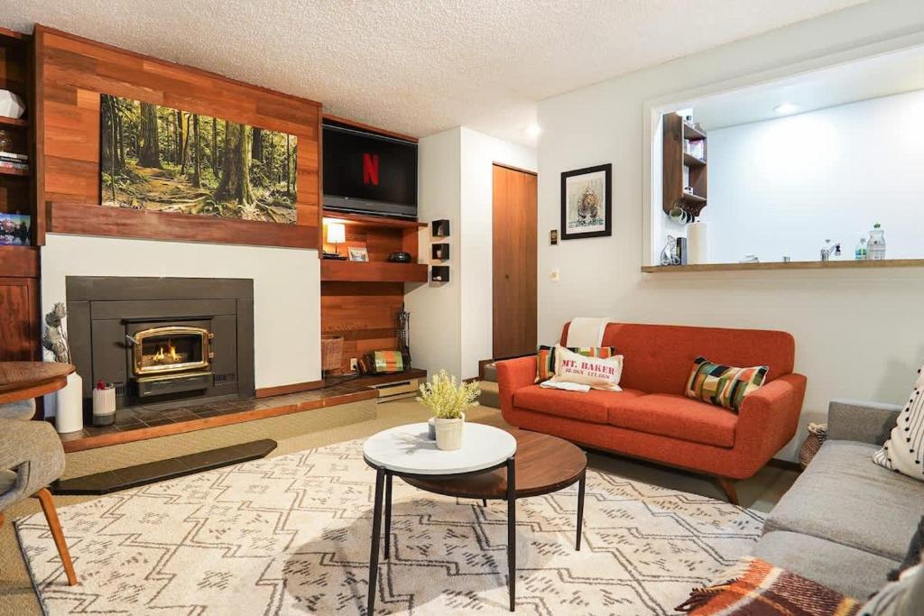 a living room with a couch and a fireplace at Cedar Suite at Snowater in Glacier