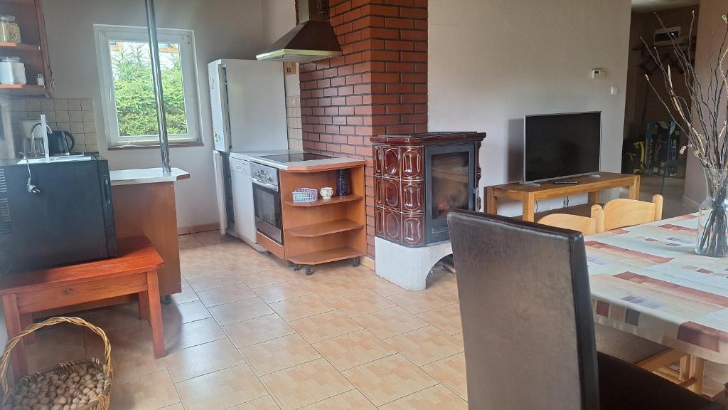 a kitchen with a fireplace and a table with a table sidx sidx sidx at Domek nad jeziorem in Dorotowo