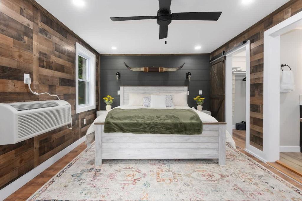 a bedroom with a bed and a fan at Stylish KC FarmhouseHugeFencedYard in Merriam