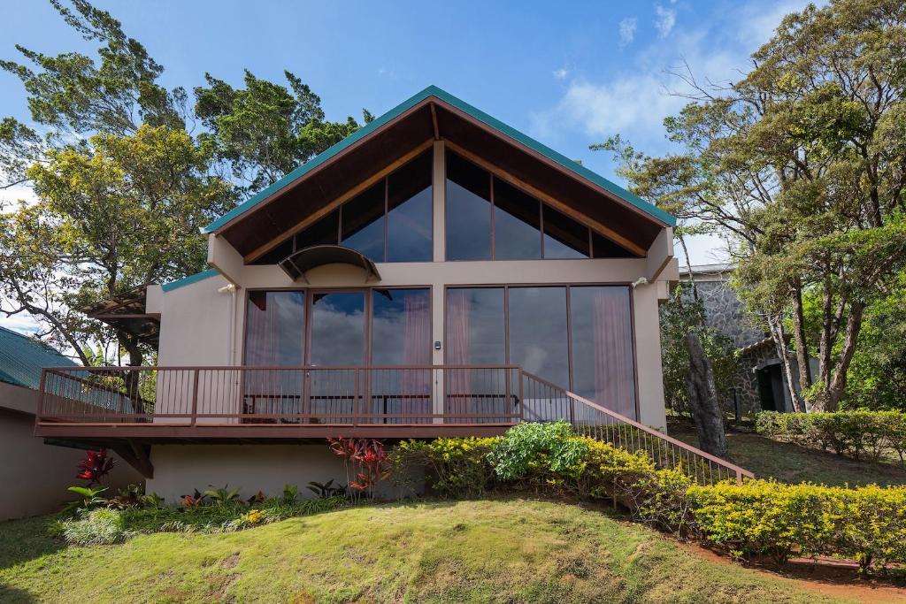 a house with a balcony and large windows at Green Forest Rustic Houses in Monteverde Costa Rica