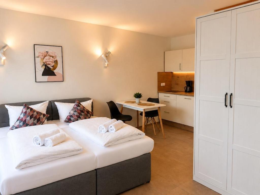 a bedroom with a bed and a kitchen with a table at Lake Vibe Studio Apartment Wangen in Öhningen