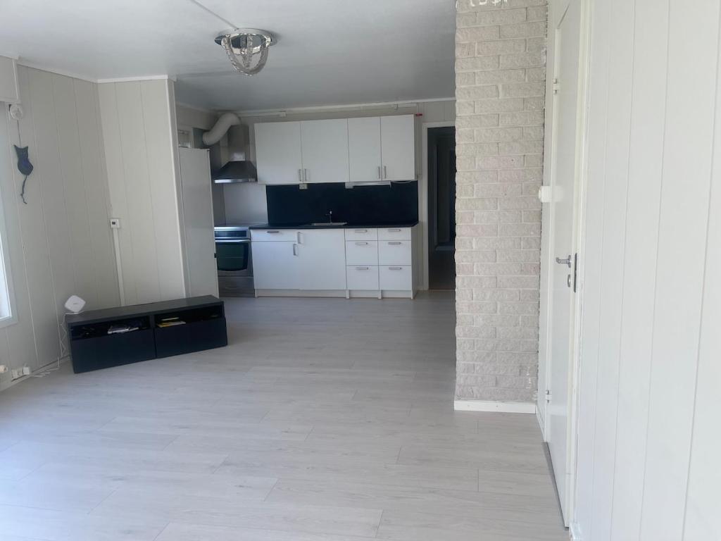 a kitchen with white cabinets and a tile floor at Best place to live in Trondheim