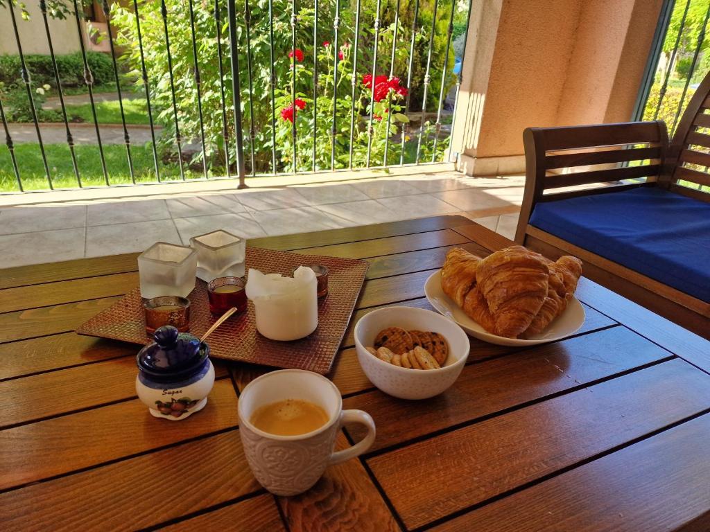 a wooden table with a breakfast of coffee and croissants at Kaliakria Garden in Topola
