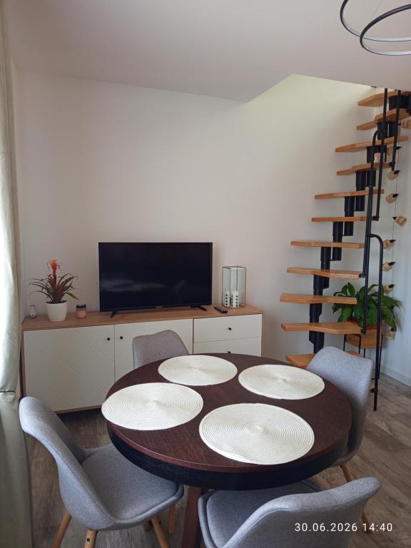 a dining room with a table and chairs and a staircase at Miła Przystań in Debrzno