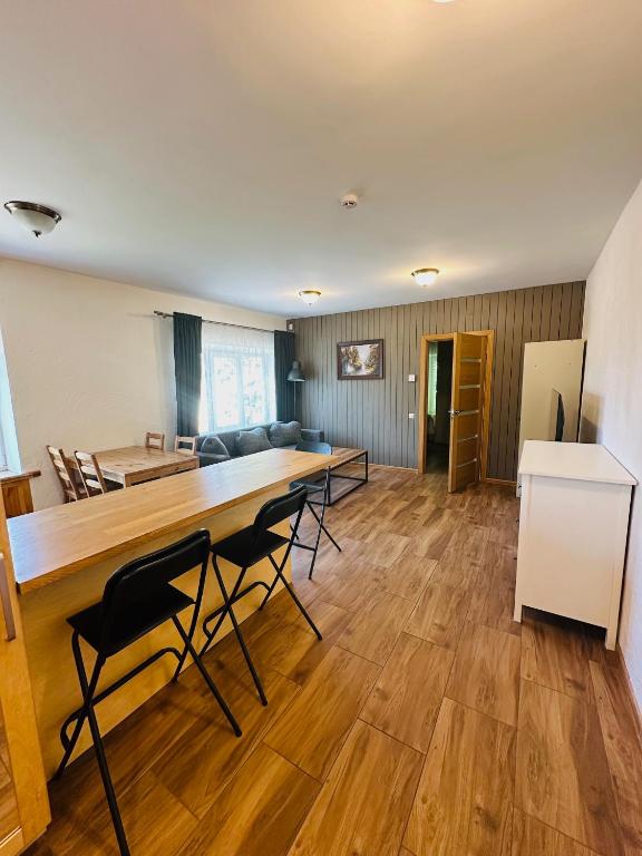 a living room with a large wooden table and chairs at Rožu namu apartamenti 6 in Kuldīga