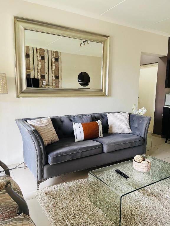 a black leather couch in a living room with a mirror at CLASSY and COZY 3 in Fourways