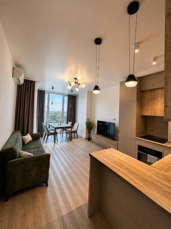 a living room with a couch and a table at Tropical Garden apart hotel in Batumi