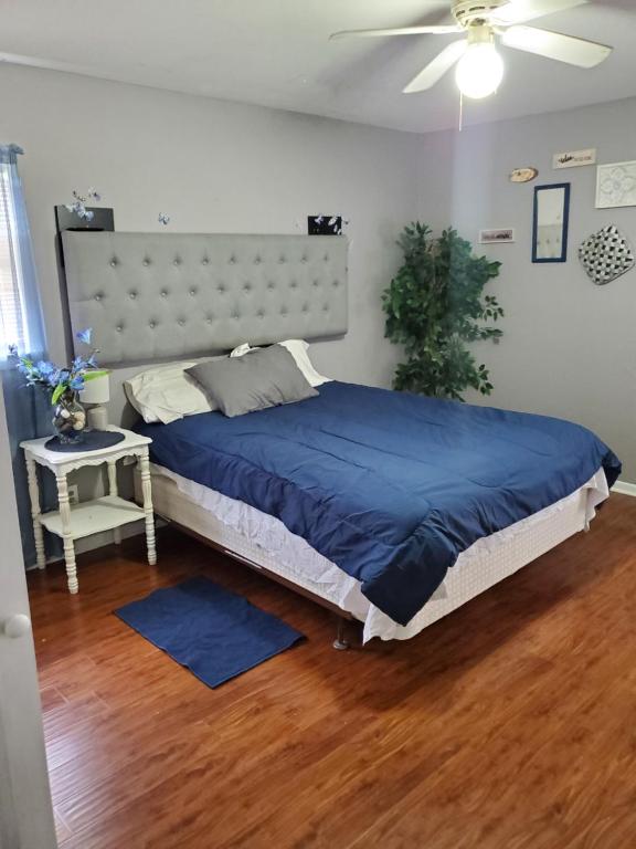 a bedroom with a large bed with a blue blanket at Comfortable home in Mobile