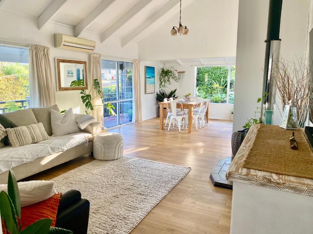 a living room with a couch and a table at Tairua Tides - Relaxed Coastal Retreat in Tairua
