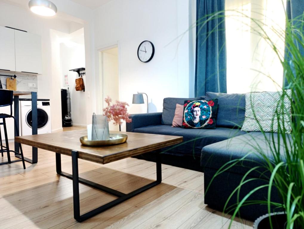a living room with a blue couch and a coffee table at DOWNTOWN 4 in Alexandroupoli