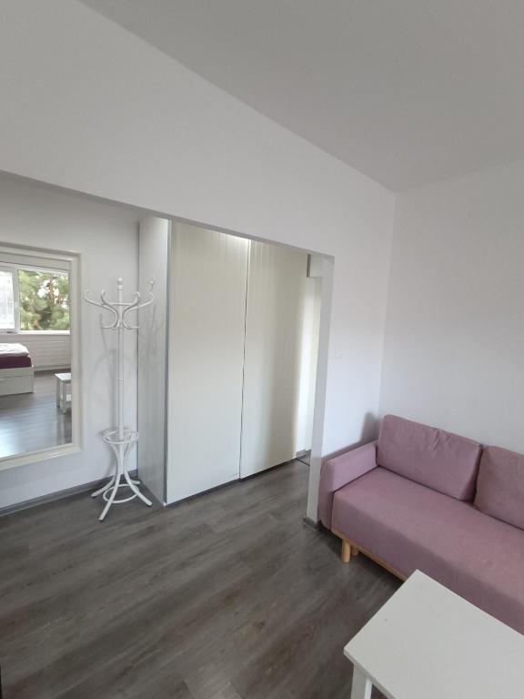 a living room with a purple couch and a table at 1-room apartment in Nitra