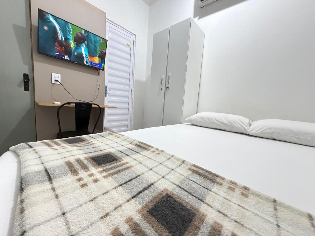 a bedroom with a bed and a tv on a wall at Mini Ap no derby com Garagem in Sobral