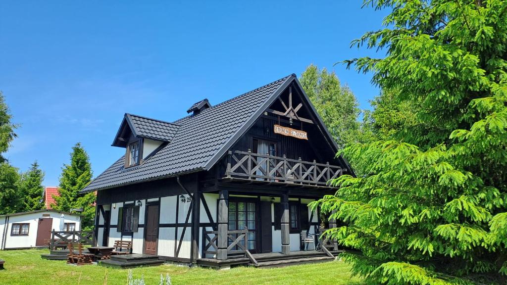 a black house with a black roof at Siedlisko Białogóra in Białogóra