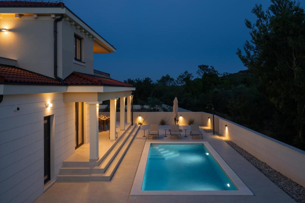 a swimming pool on the side of a house at Villa DaEva in Drage