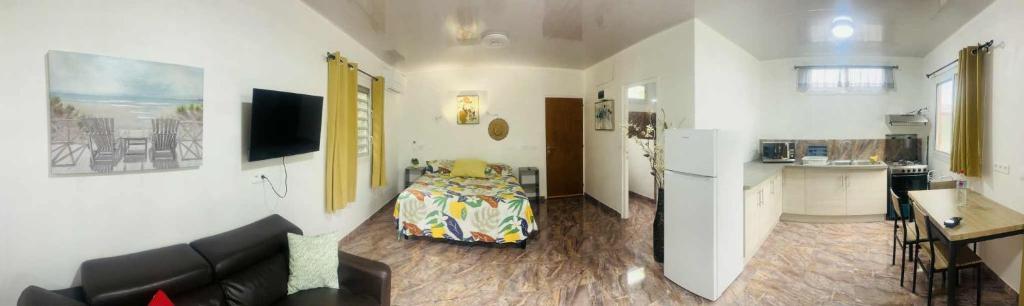 a living room with a couch and a kitchen at Bungalow tatayo in Aua