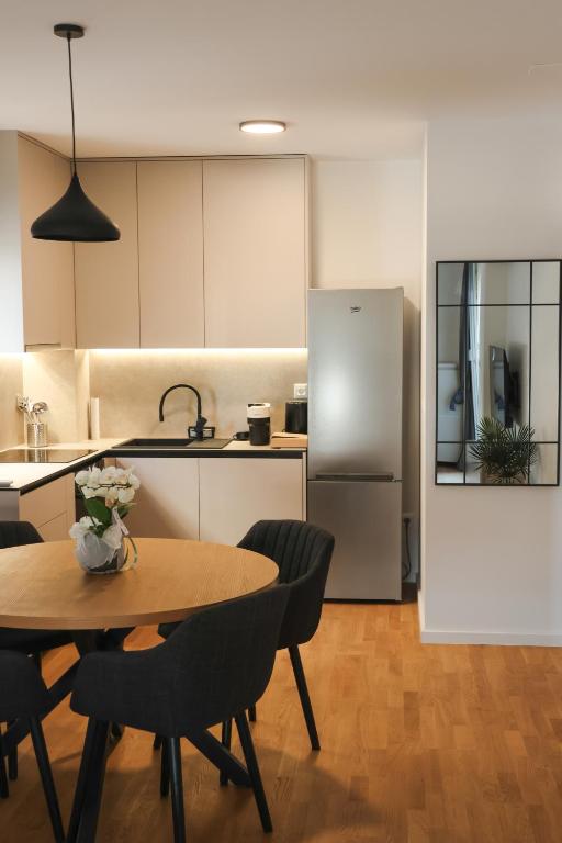 a kitchen with a table and chairs and a refrigerator at MODERN ESCAPE apartment with garage in Split