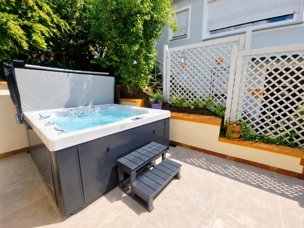 a hot tub in a backyard with a fence at PMC Traumblick Suite & Spa - Whirlpool & Sauna in Bad Ems