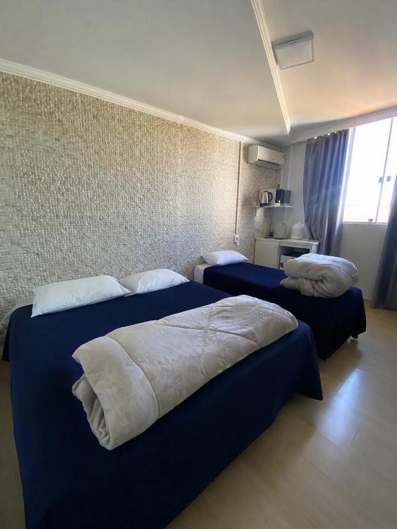 a hotel room with two beds in a room at Loft Lux SM Chapecó - Amplo e aconchegante! in Chapecó
