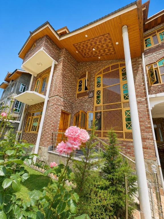a house with pink roses in the front yard at Sultan Homestay in Srinagar