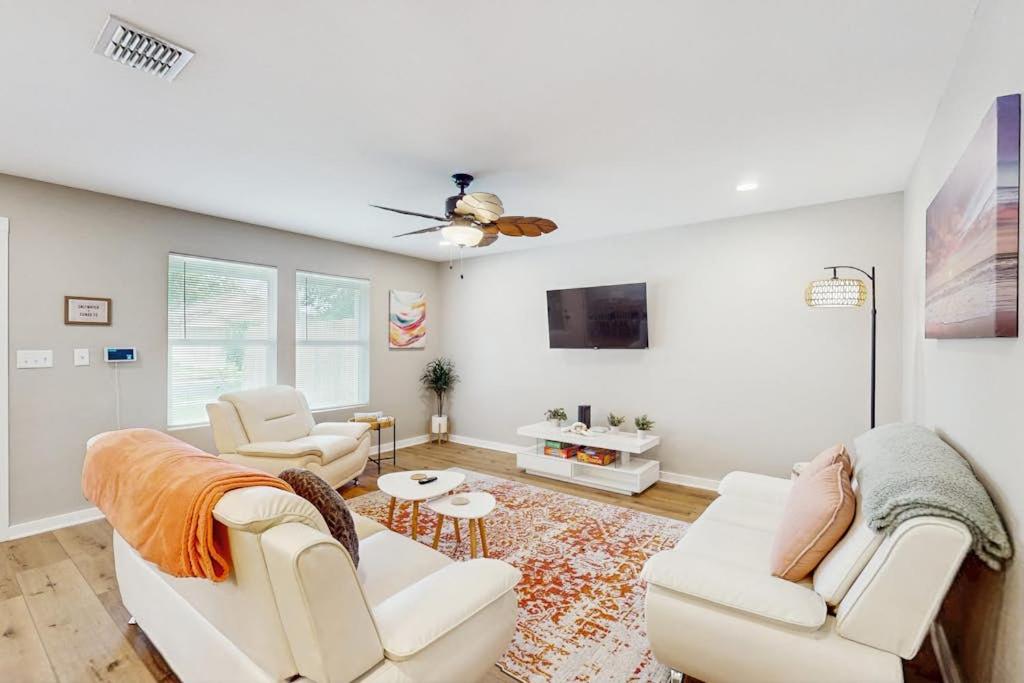 a living room with white furniture and a ceiling fan at Emerald Escape in Corpus Christi