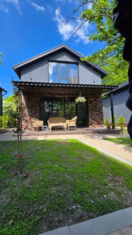 a house with a table and chairs in front of it at Arcadia Family Vacation House in Çilǝgir