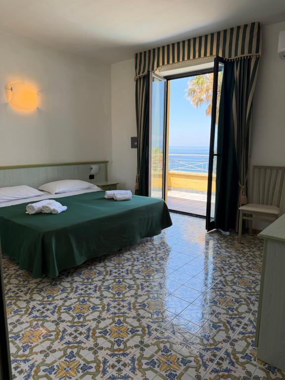 a bedroom with a bed and a door to the ocean at Belvedere Blu b&b & beach in Belvedere Marittimo