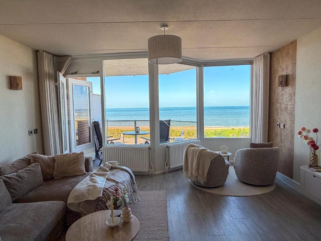 a living room with a couch and a view of the ocean at Casa Amare in Egmond aan Zee