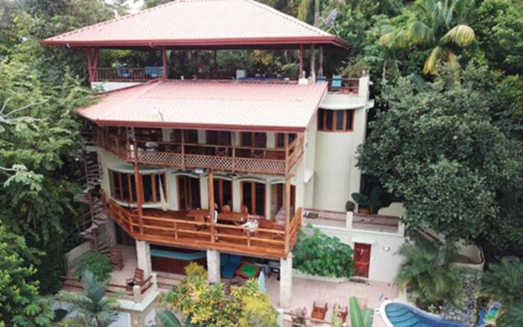a large house with a large porch on top of it at Casa Pura Paz in Puntarenas