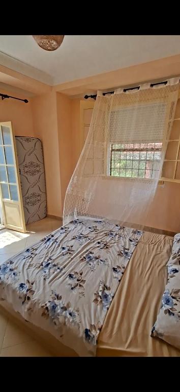 a bedroom with a bed with a curtain and a window at اولاد بونار in Jijel