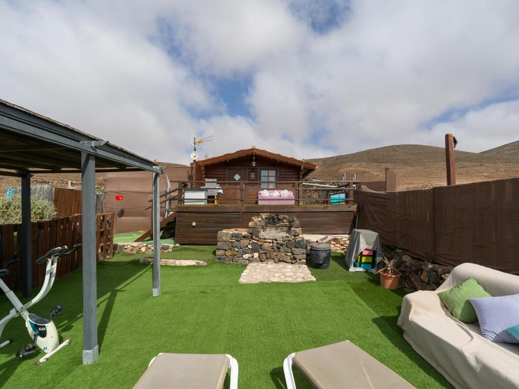 a backyard with green grass and a cabin at La Maxada Luz Maria in El Cotillo