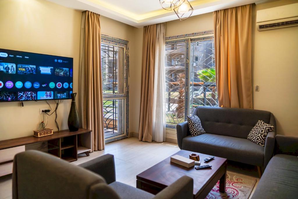 a living room with a couch and a tv at 903 . Spacious 3BR Apt. 2 Baths Gated Community in Sheikh Zayed