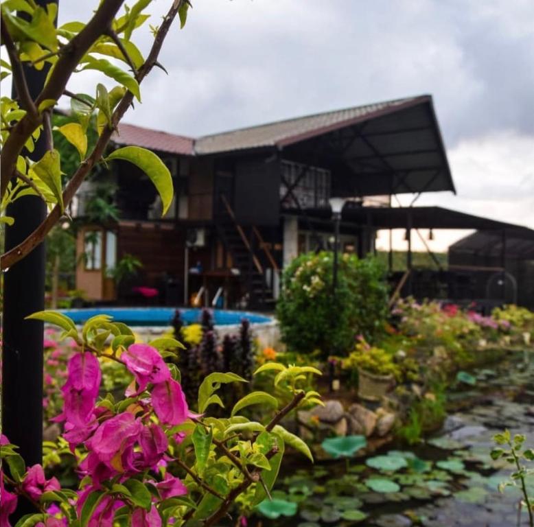 a garden with pink flowers in front of a building at Villas by Helanka in Gonawala