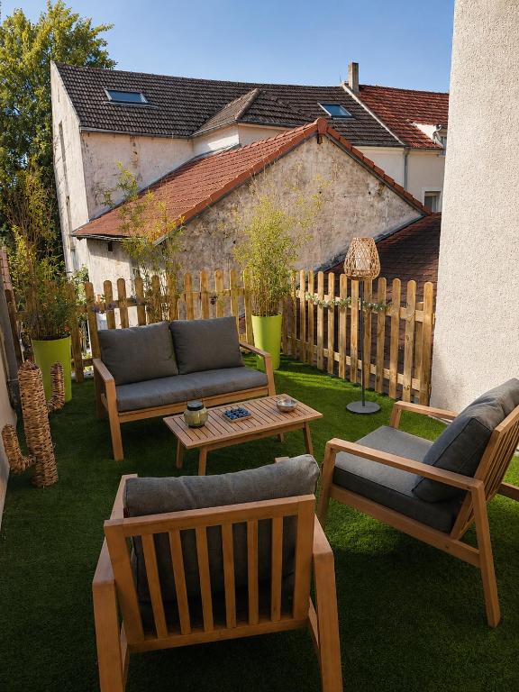 a patio with couches and a table and a fence at ROOMS HOME CSM Suites privees élégantes entre Reims et Disneyland Paris 1 à 8 personnes in Charly-sur-Marne