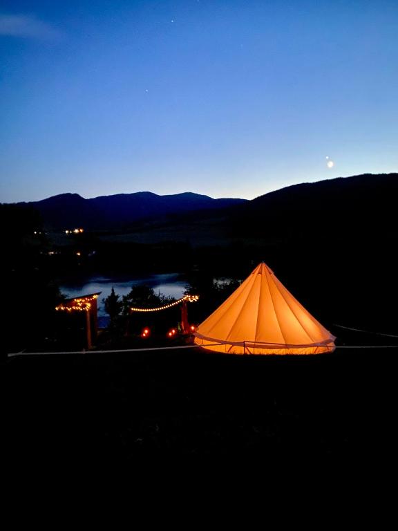 an orange tent is lit up at night at Zálesie Glamping in Kostolná Ves