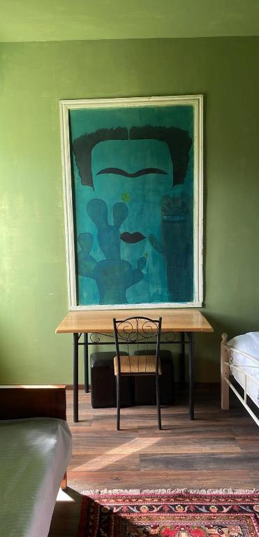 a table in a room with a painting on the wall at Rails and Vines in Tsinandali