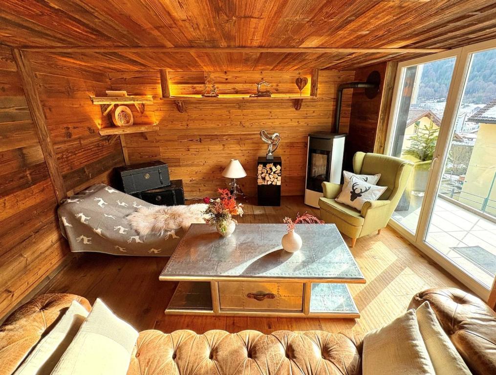 a living room with a couch and a table at Alpine Chic Escape with Spa & Panoramic Views in Engelberg
