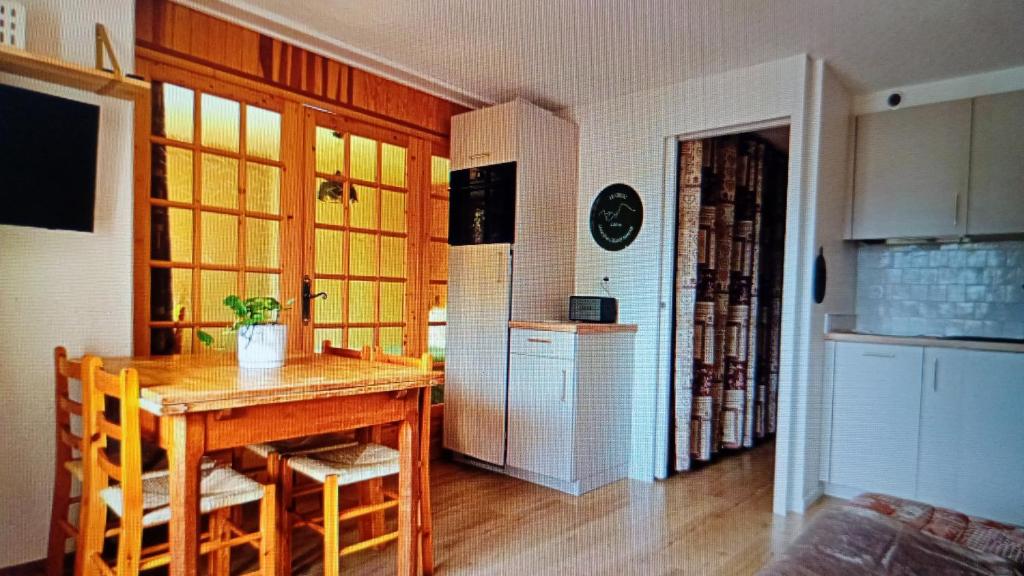 a kitchen with a wooden table and a refrigerator at Dorfgastein Mountain Property - Charming in Dorfgastein