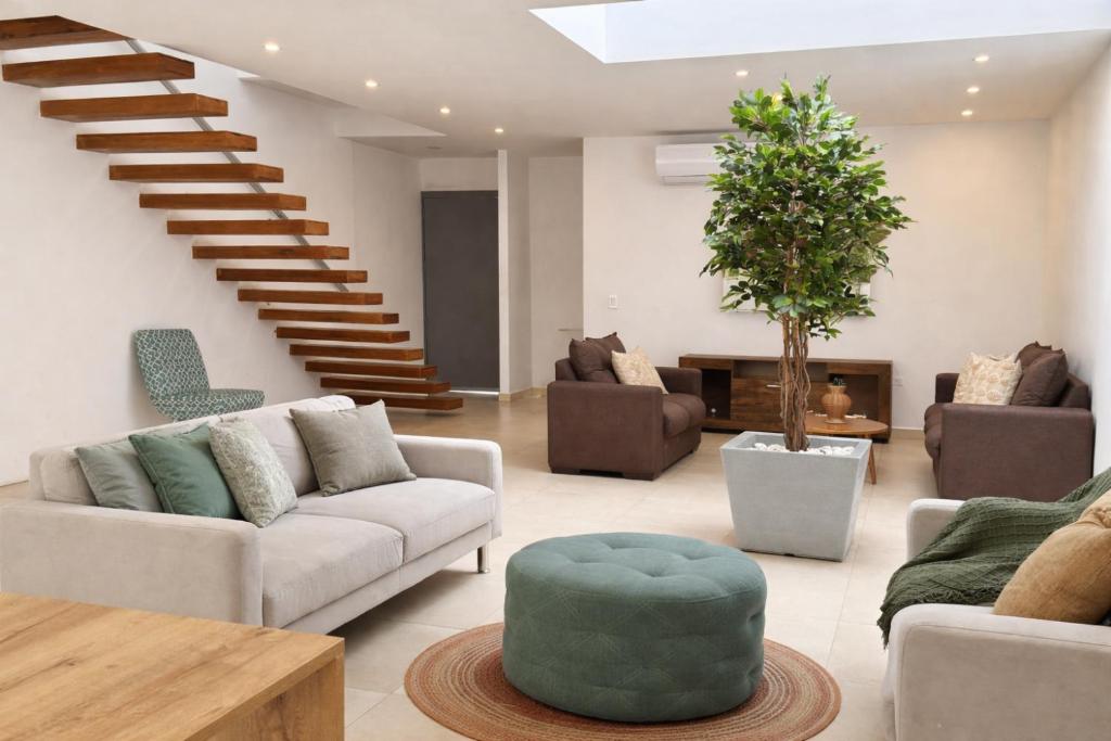 a living room with couches and a stair case at Urbanización privada, seguridad y confort in Manta