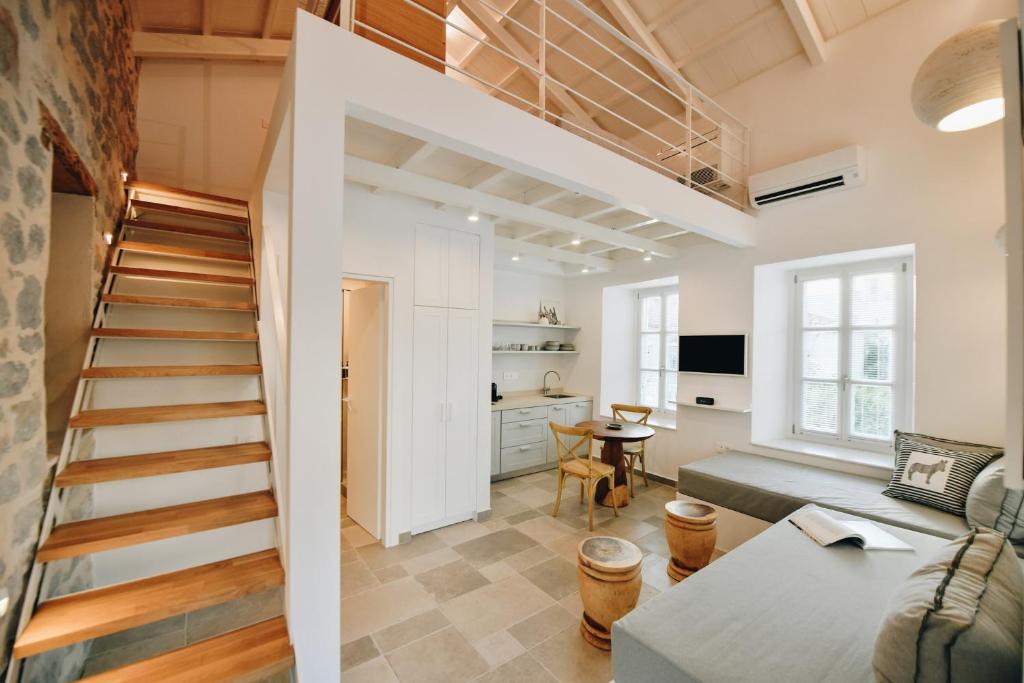 a loft with a staircase and a living room at Calais Boutique Apartments in Hydra