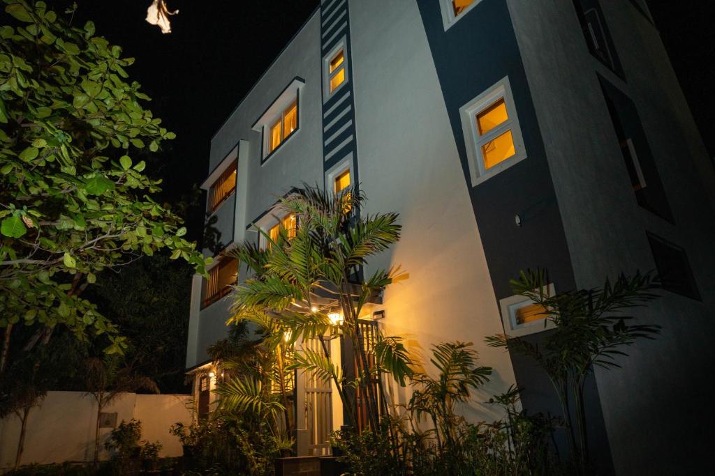 a building with palm trees in front of it at night at Sivam Villa-Kovalam in Covelong