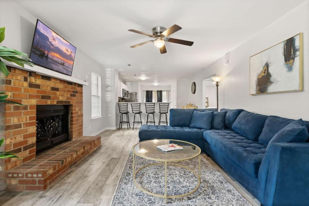 a living room with a blue couch and a fireplace at A Peaceful stay at The Pine Grove Retreat in Ladson