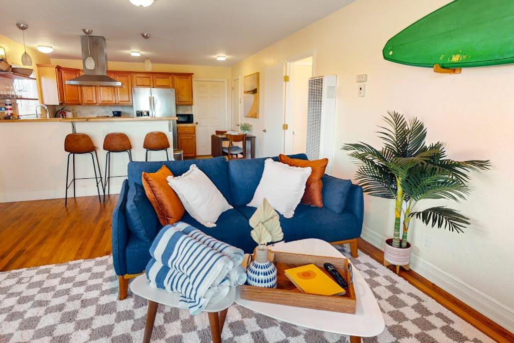 a living room with a blue couch and a kitchen at Deep Blue Seaside in Monterey