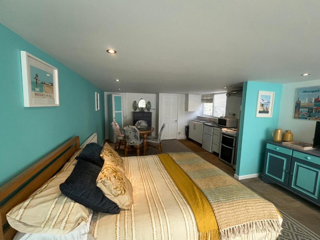 a bedroom with a large bed with blue walls at Margate Summerhouse in Westgate-on-Sea