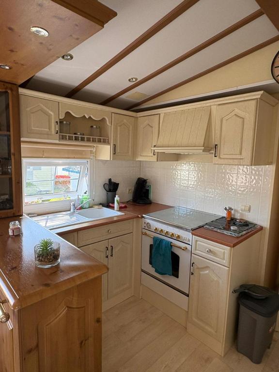 a kitchen with white cabinets and a stove top oven at Mobil home in Ambon