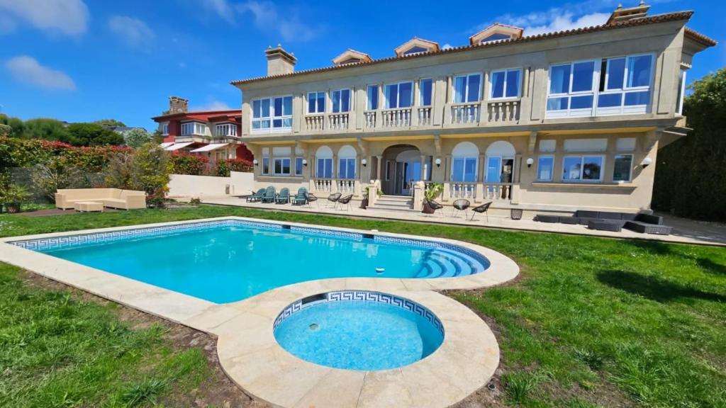 an estate with a swimming pool in front of a house at Gran Room do Mar in Oya