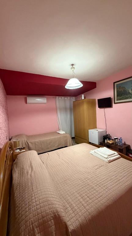 a hotel room with a large bed and a red wall at Casa Valeria in Pescia