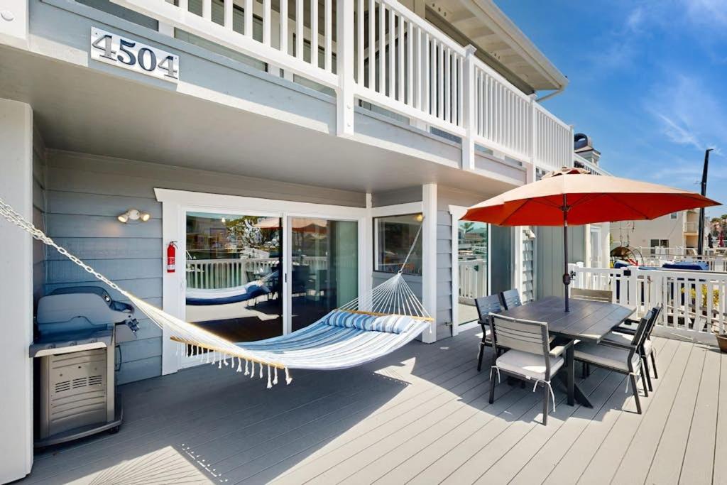 eine Hängematte auf einer Veranda mit Tisch und Stühlen in der Unterkunft Gateshead Haven in Oxnard