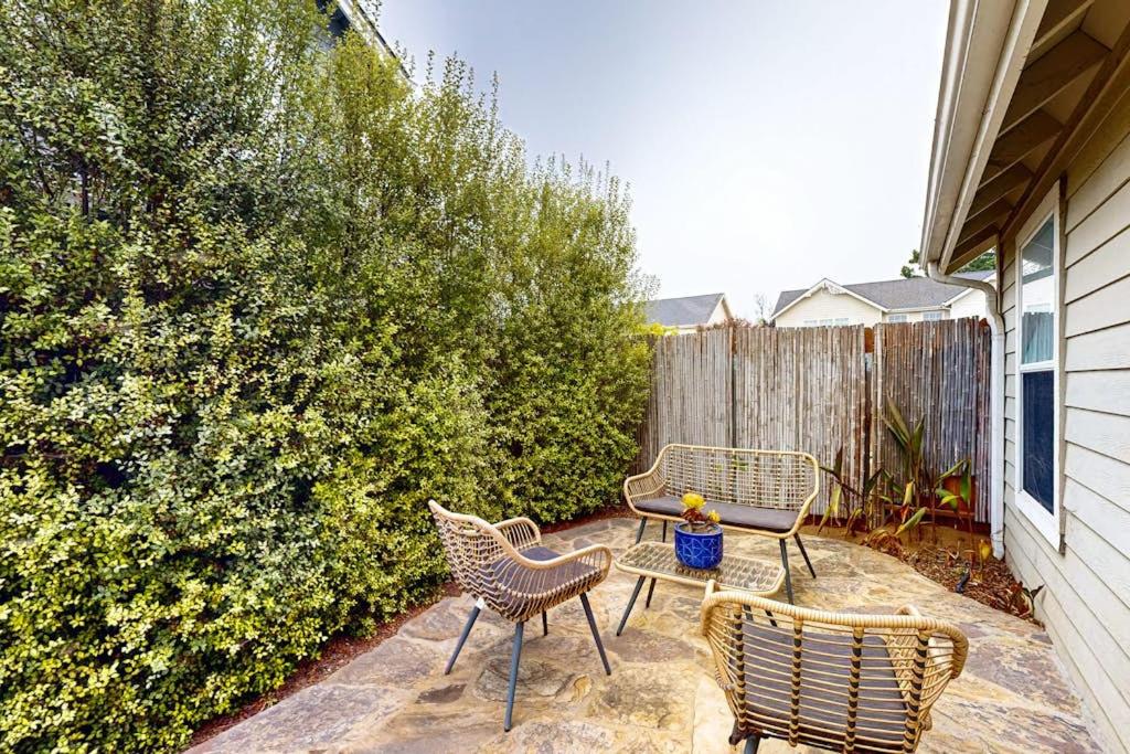 a patio with three chairs and a table and a fence at Dune Delight in Arroyo Grande