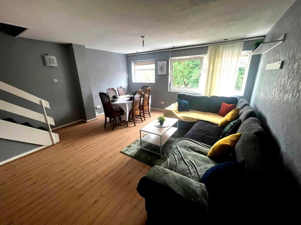 a living room with a couch and a table at Large river side house, parking,for 9 people in Bedford
