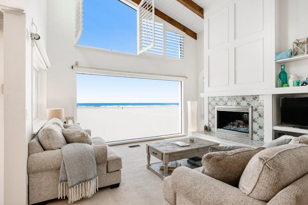 a living room with two couches and a fireplace at Sandcastle by the Sea in Oxnard